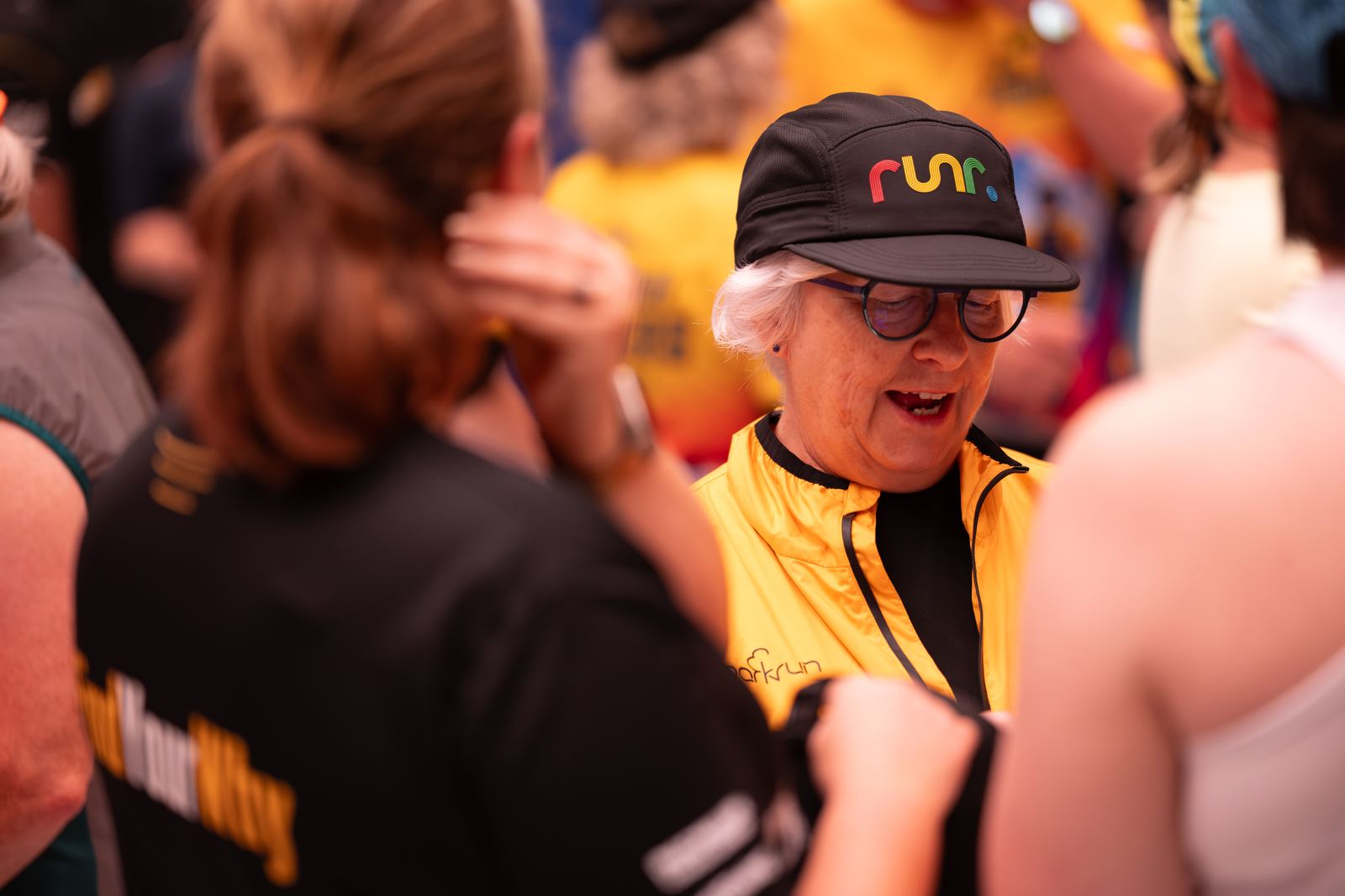 A smiling attendee connecting with other runners at the runr social